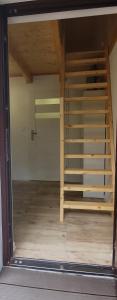 an empty room with a wooden staircase in a building at Domki u Remika in Pobierowo