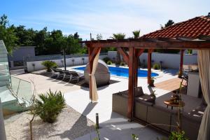 a backyard with a swimming pool and a pergola at Villa Golden Apple in Seline
