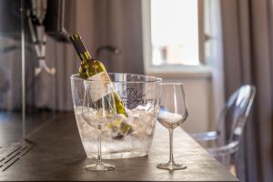 a bottle of wine sitting in a bucket on a table with two glasses at Exclusive Rooms in Casa Manzolin in Poreč