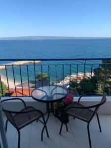 a balcony with a table and chairs and the beach at Hotel Elu Iris in Split