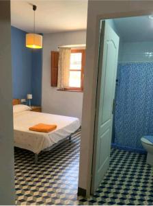 1 dormitorio con 1 cama y baño con aseo en Casa Rural Hotel La Placeta AYORA en Ayora