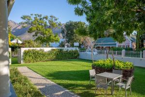 a patio with a table and chairs in a yard at Monte Vista Boutique Hotel in Montagu