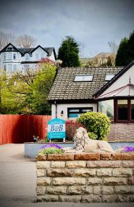 a lion statue sitting in front of a house at Ardlinnhe Bed & Breakfast in Fort William