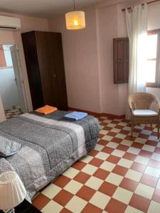 a bedroom with a bed and a checkered floor at Casa Rural Hotel La Placeta AYORA in Ayora