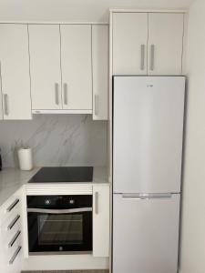 eine Küche mit weißen Schränken und einem Kühlschrank in der Unterkunft Casa Vileros in L'Ampolla
