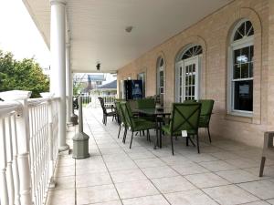 un patio con sillas verdes y una mesa en una casa en The Belmar Inn, en Belmar