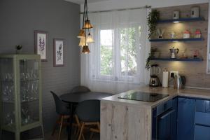 a kitchen with blue cabinets and a table and a window at Just4Us in Srima