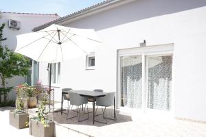 a patio with a table and chairs and an umbrella at Just4Us in Srima