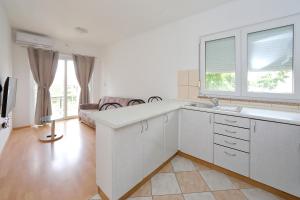 cocina con armarios blancos y ventana grande en Pepi Apartments 2 en Zadar