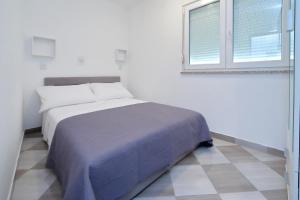Habitación blanca con cama y ventana en Pepi Apartments 2 en Zadar