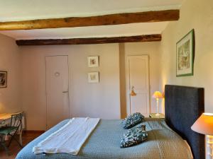 um quarto com uma cama azul com almofadas em Domaine La Condamine CRILLON LE BRAVE em Crillon-le-Brave