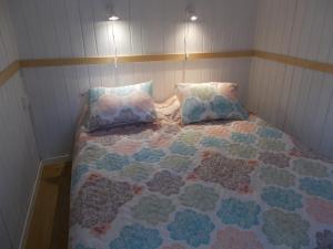 uma cama com duas almofadas e uma colcha em Lilla Stugan, Sjötorp em Mariestad