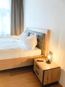 a bedroom with a bed and a table with a lamp at APARTMENTS zum Wohlfühlen MARIAZELL in Mariazell