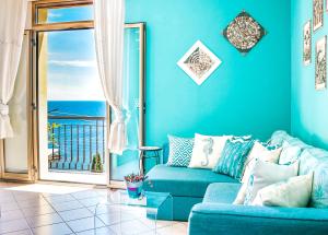 a blue living room with a couch and a balcony at Cohen Smart House in Taormina