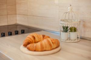 a couple of croissants and a bird cage on a counter at Apartments Ruzmarin in Herceg-Novi