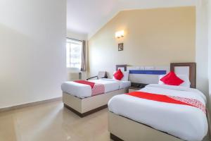 a hotel room with two beds and a couch at Hotel City Garden in Madgaon