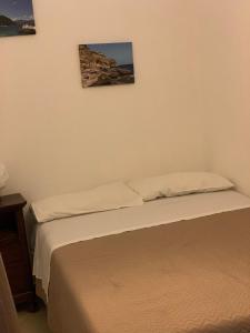 two beds in a bedroom with two pictures on the wall at Casa Casteldaccia 2 in Casteldaccia