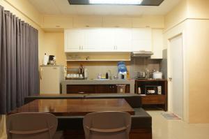 a kitchen with a table and chairs and a refrigerator at Mint Homes in CEV Mansion in Manila