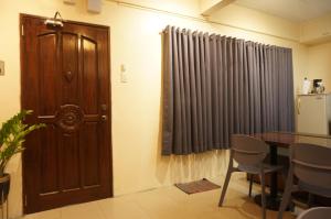 a dining room with a door and a table and chairs at Mint Homes in CEV Mansion in Manila
