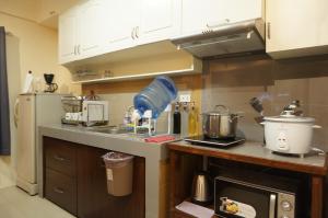 a kitchen with a counter with a refrigerator and a counter sidx sidx sidx at Mint Homes in CEV Mansion in Manila