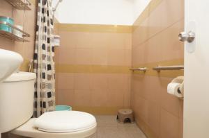 a small bathroom with a toilet and a shower at Mint Homes in CEV Mansion in Manila +7 photos