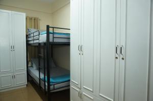 a room with two bunk beds and white cabinets at Mint Homes in CEV Mansion in Manila
