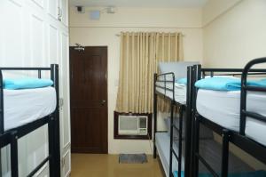a room with three bunk beds and a door at Mint Homes in CEV Mansion in Manila