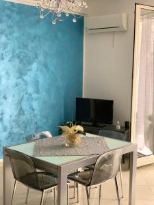 a dining room table with chairs and a blue wall at Casa Casteldaccia 2 in Casteldaccia