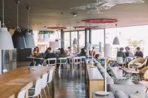 a group of people sitting at tables in a restaurant at Hotel Rec Barcelona - Adults Only in Barcelona