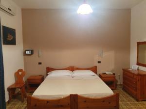 レ・カステッラにあるHotel Annibaleのベッドルーム1室(ベッド1台、テーブル2台、鏡付)