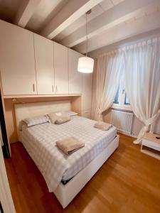 ein Schlafzimmer mit einem weißen Bett und einem Fenster in der Unterkunft Belvedere Home in Desenzano del Garda