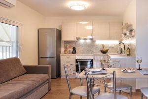 a kitchen and living room with a table and a couch at Villa IRENE in Zóla