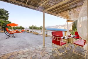 patio con tavolo e sedie rosse di Villa IRENE a Zóla