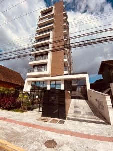 um edifício alto com muitas janelas em MaxLoft - Apto novo Smart Tv, lavanderia em Joinville