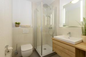 een badkamer met een douche, een toilet en een wastafel bij Hotel Sonnbichl in Lam
