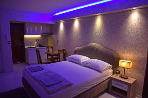 sypialnia z dużym łóżkiem z fioletowym oświetleniem w obiekcie Apartments Daki w mieście Igalo