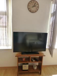 una TV a schermo piatto su un tavolo con un orologio a muro di Apartment La Rosa (Konstanz) a Costanza