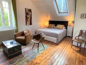 a bedroom with a bed and a chair and a table at Chambres d'Hôtes Couleurs du Temps in Périgueux