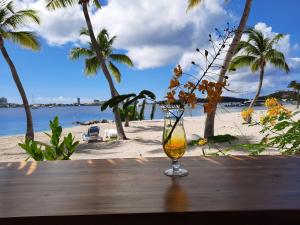 ein Glas Wein auf einem Tisch am Strand in der Unterkunft flamboyant in Marigot