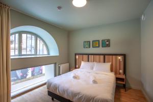 um quarto com uma cama e uma grande janela em The People - Strasbourg em Estrasburgo