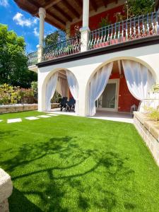 einen Hof mit grünem Gras und ein Haus mit Balkon in der Unterkunft Belvedere Home in Desenzano del Garda