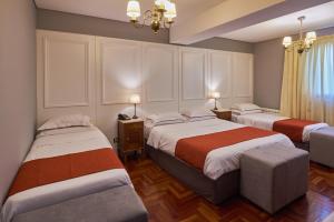 
a hotel room with two beds and two lamps at Altos de Guemes Hotel in Mar del Plata
