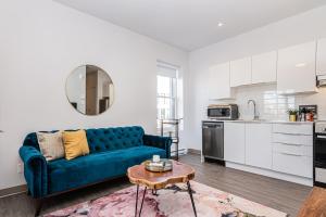 a living room with a blue couch and a table at Huge New Flat well Located closed on St-Denis Street by Den Stays in Montreal