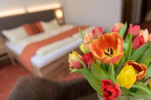 eine Vase voller bunter Blumen in einem Zimmer in der Unterkunft Hotel Sonnbichl in Lam