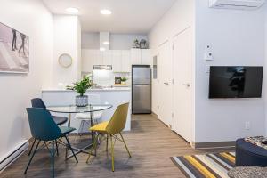 una cucina e una sala da pranzo con tavolo e sedie di New Urban and Well Located 1 Bedroom Apartment by Den Stays a Montréal