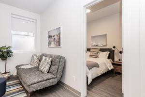 a bedroom with a bed and a chair and a mirror at New Urban and Well Located 1 Bedroom Apartment by Den Stays in Montreal