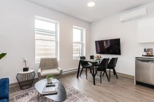 a living room with a table and chairs and a tv at Modern and New Studio in the Heart of the City by Den Stays in Montréal