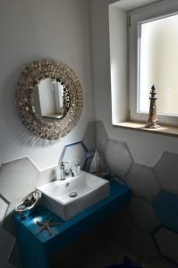 a bathroom with a white sink and a mirror at CàSolare Country House in Sperlonga