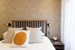 1 dormitorio con 1 cama con almohadas blancas en Scandinavian Studio with Full Kitchen and Bath by Den Stays en Montreal