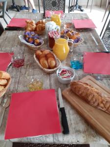 a table topped with baskets of bread and baskets of pastries at L'Auberge du Mazet in Lodève